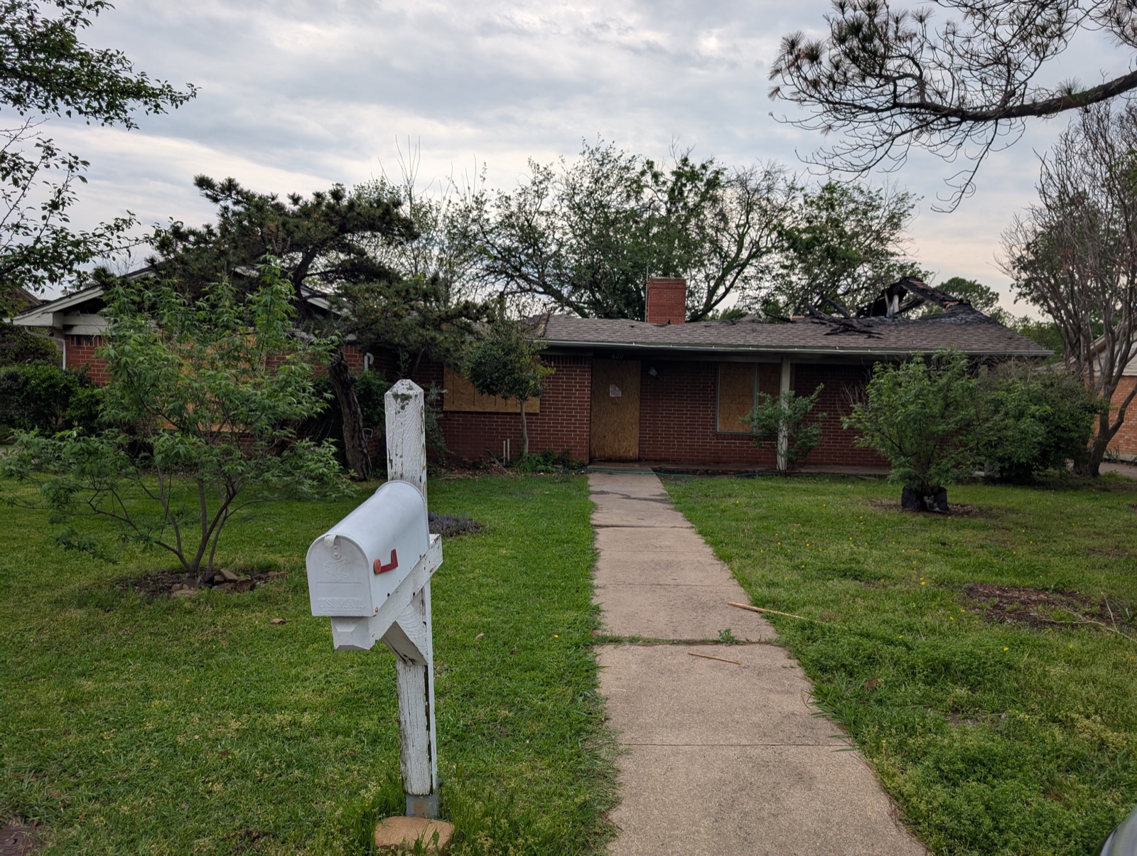 Fire-damaged front exterior of a Denton, TX home before restoration